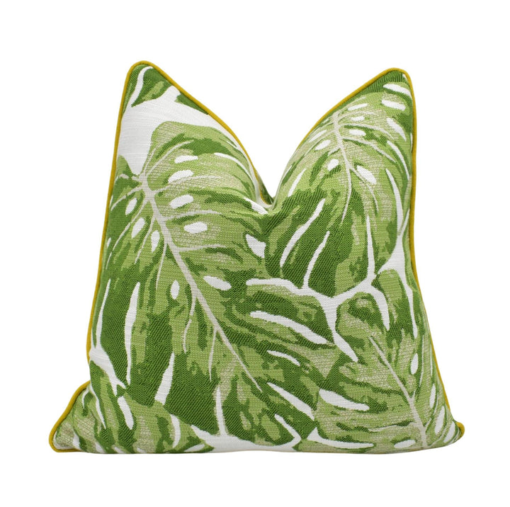 A green and white throw pillow with a leaf pattern design.