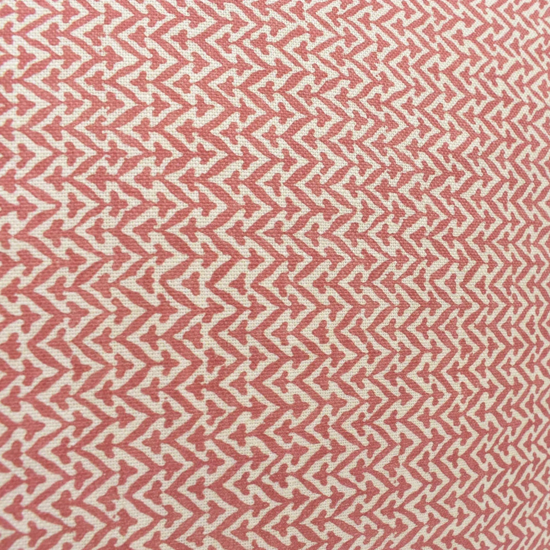 a close-up view of a fabric with a repeating pattern of red and white triangles. The pattern is arranged in a diagonal direction, creating a zigzag effect across the fabric. The fabric appears to be made of a soft, textured material, possibly cotton or linen.