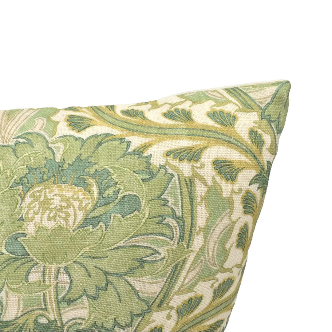 A close-up view of a decorative pillow with a green and white floral pattern.