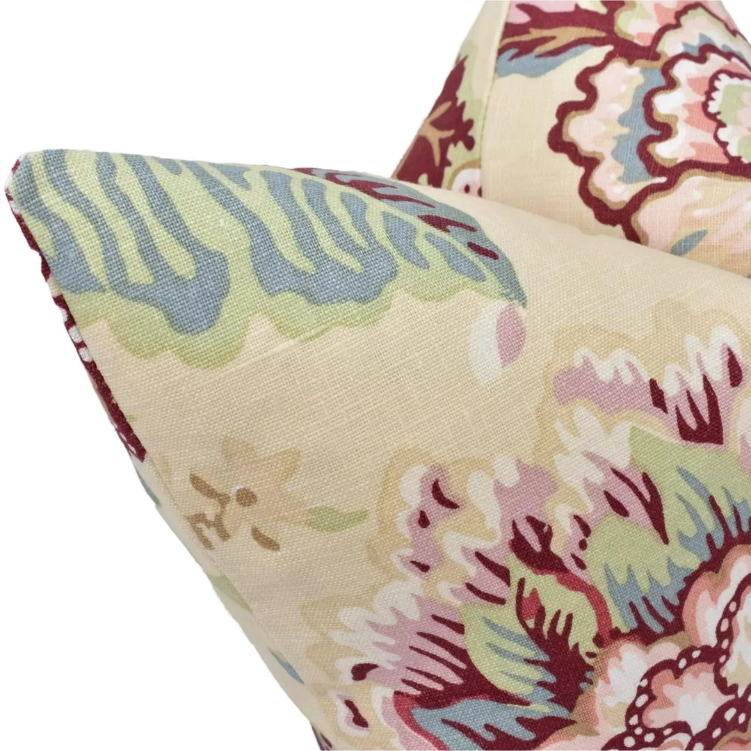 a close-up view of a decorative fabric with a floral pattern in shades of green, pink, and red.