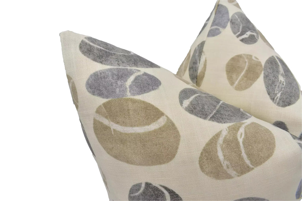 a close-up view of a beige and gray patterned pillow with a repeating design of large, round shapes.