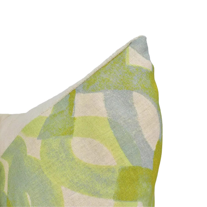 A close-up view of a colorful, abstract patterned fabric or textile, with a mix of green, yellow, and gray colors.