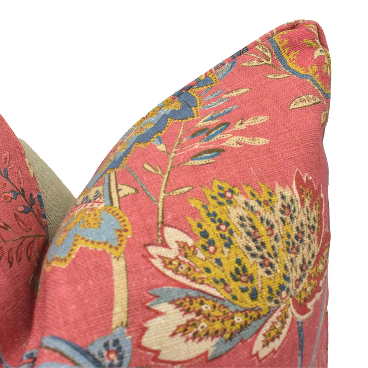 a close-up view of a vibrant, floral-patterned pillow with a mix of red, yellow, and blue colors.