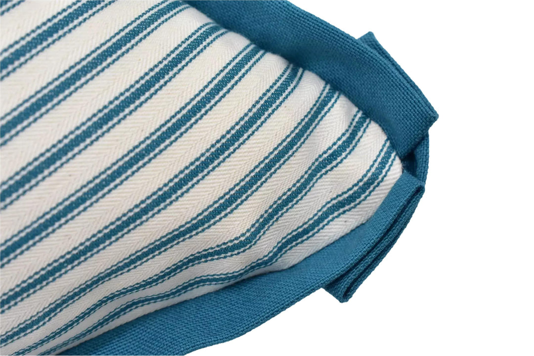 A close-up view of a striped fabric with a blue trim, likely a pillow or cushion.