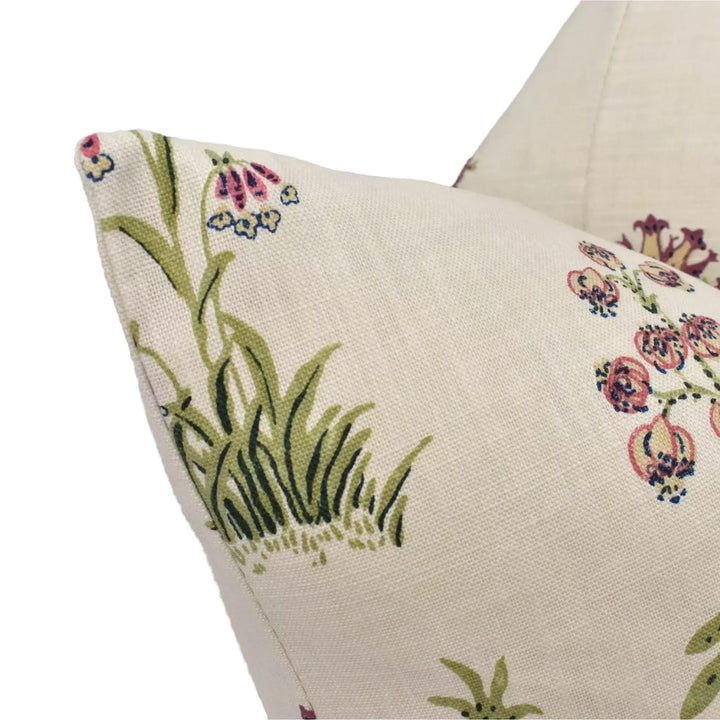 a close-up view of a beige fabric with a floral pattern, featuring green grass and pink flowers.