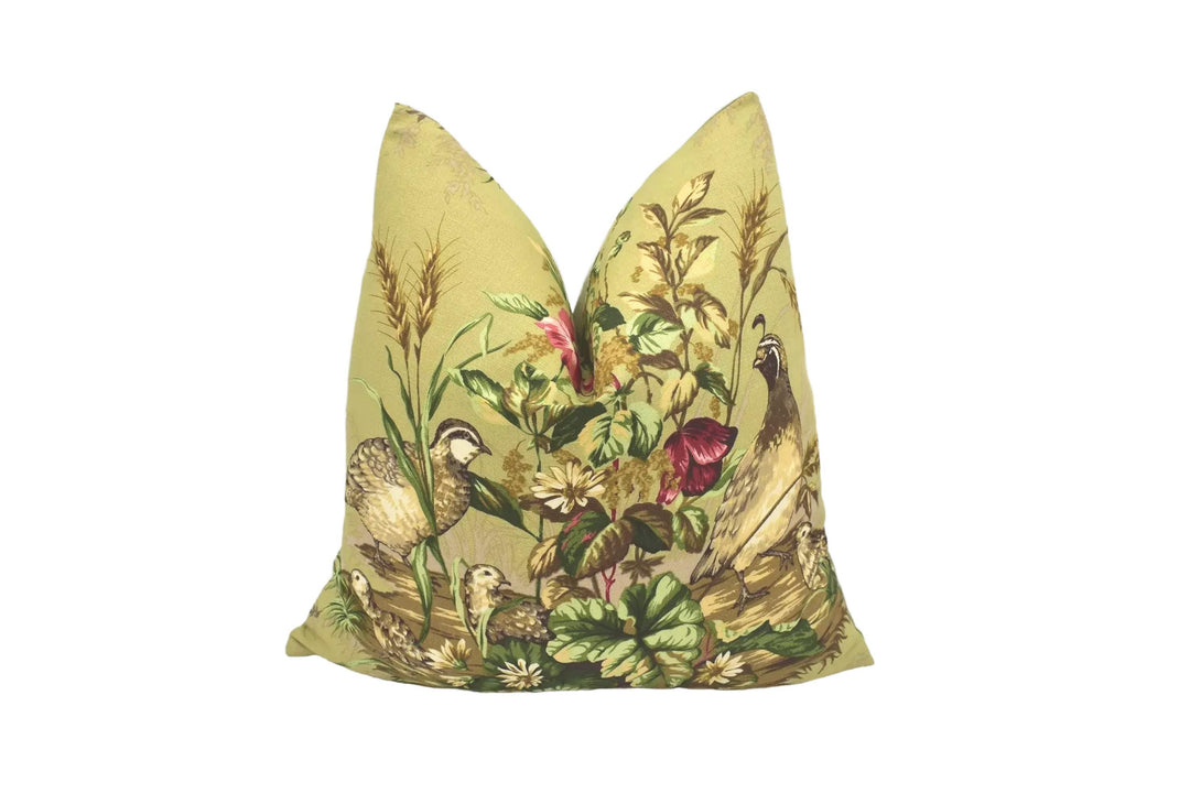 A decorative pillow with a vibrant floral and bird design, featuring a variety of colors and patterns.