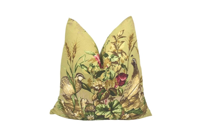 A decorative pillow with a vibrant floral and bird design, featuring a variety of colors and patterns.