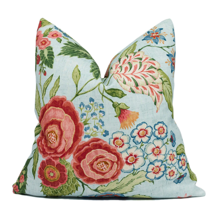 A decorative pillow with a floral pattern in shades of blue, pink, and green.
