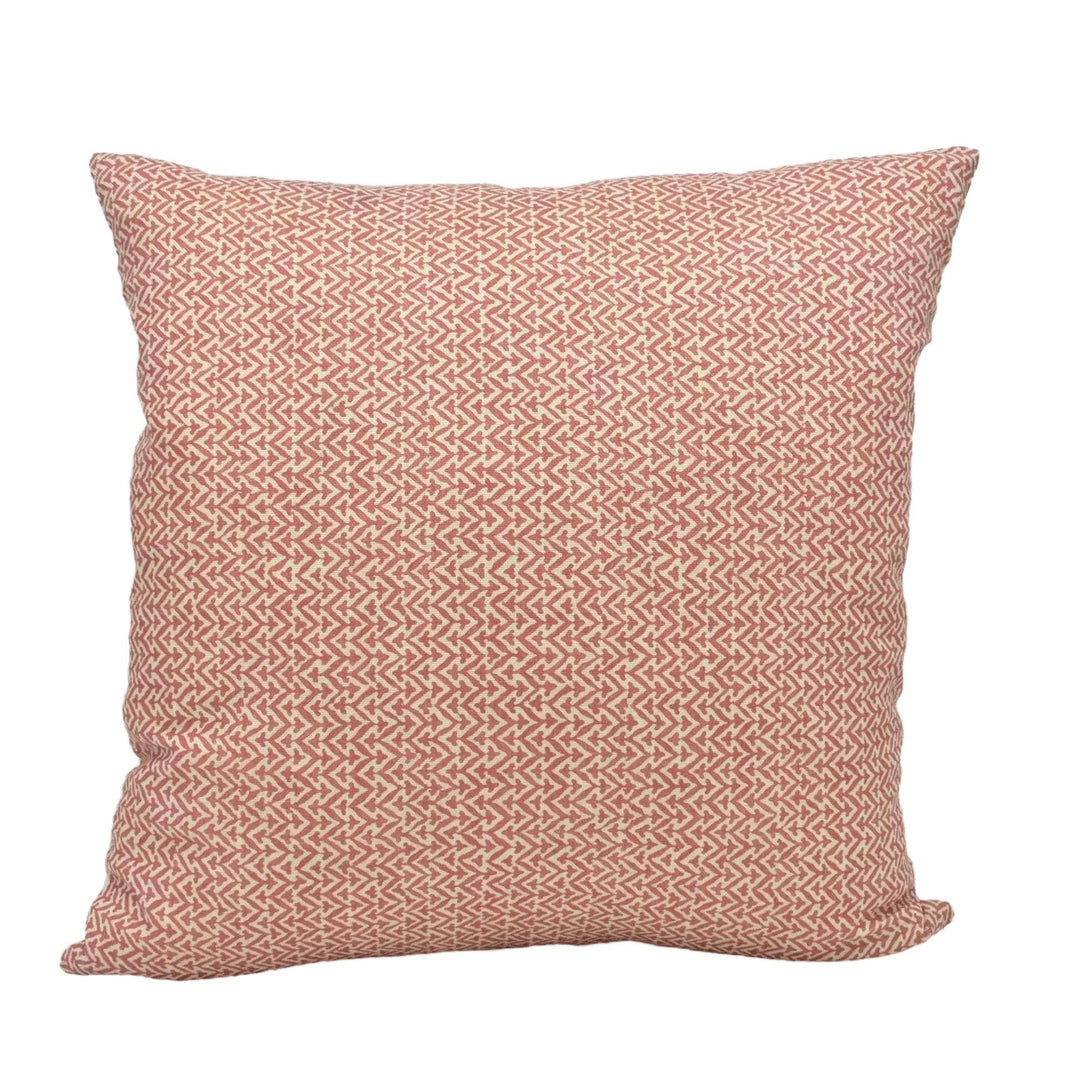 A square throw pillow with a repeating pattern of red and white geometric shapes.