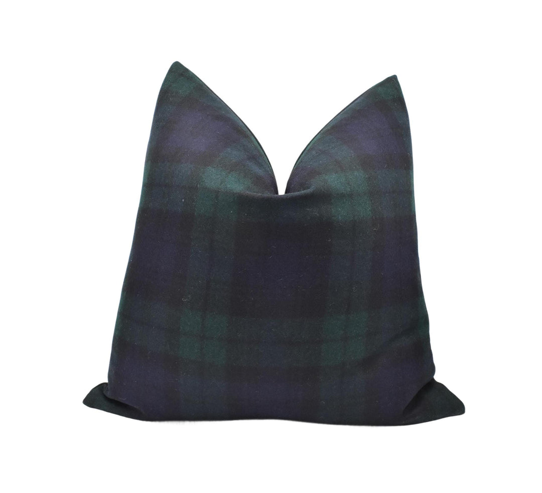 a black and green plaid pillow on a white background