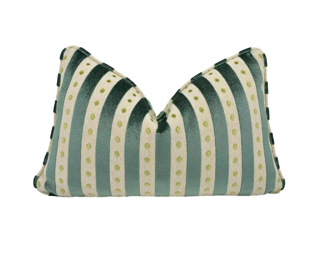 A decorative pillow with a striped pattern in shades of green and white, featuring small green dots on the fabric.