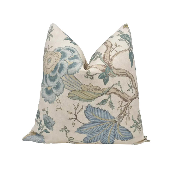 a decorative pillow with a floral pattern in shades of blue and green.