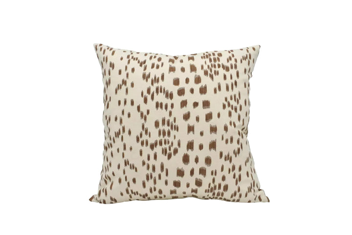 A square throw pillow with a brown spotted pattern is displayed against a white background.