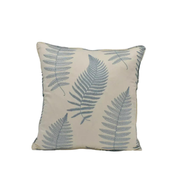 A square throw pillow with a repeating pattern of fern leaves in shades of blue and beige.