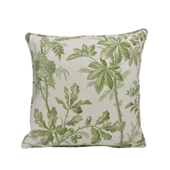 A square throw pillow with a green leaf pattern on a beige background.