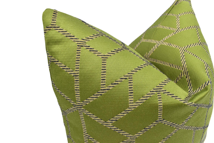 A close-up image of a green and black geometric patterned pillow.
