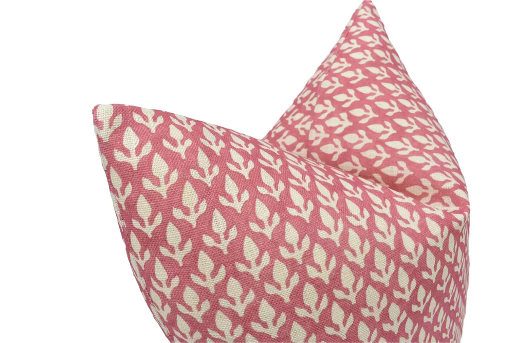 two decorative pillows with a repeating pattern of pink and white flowers or leaves.