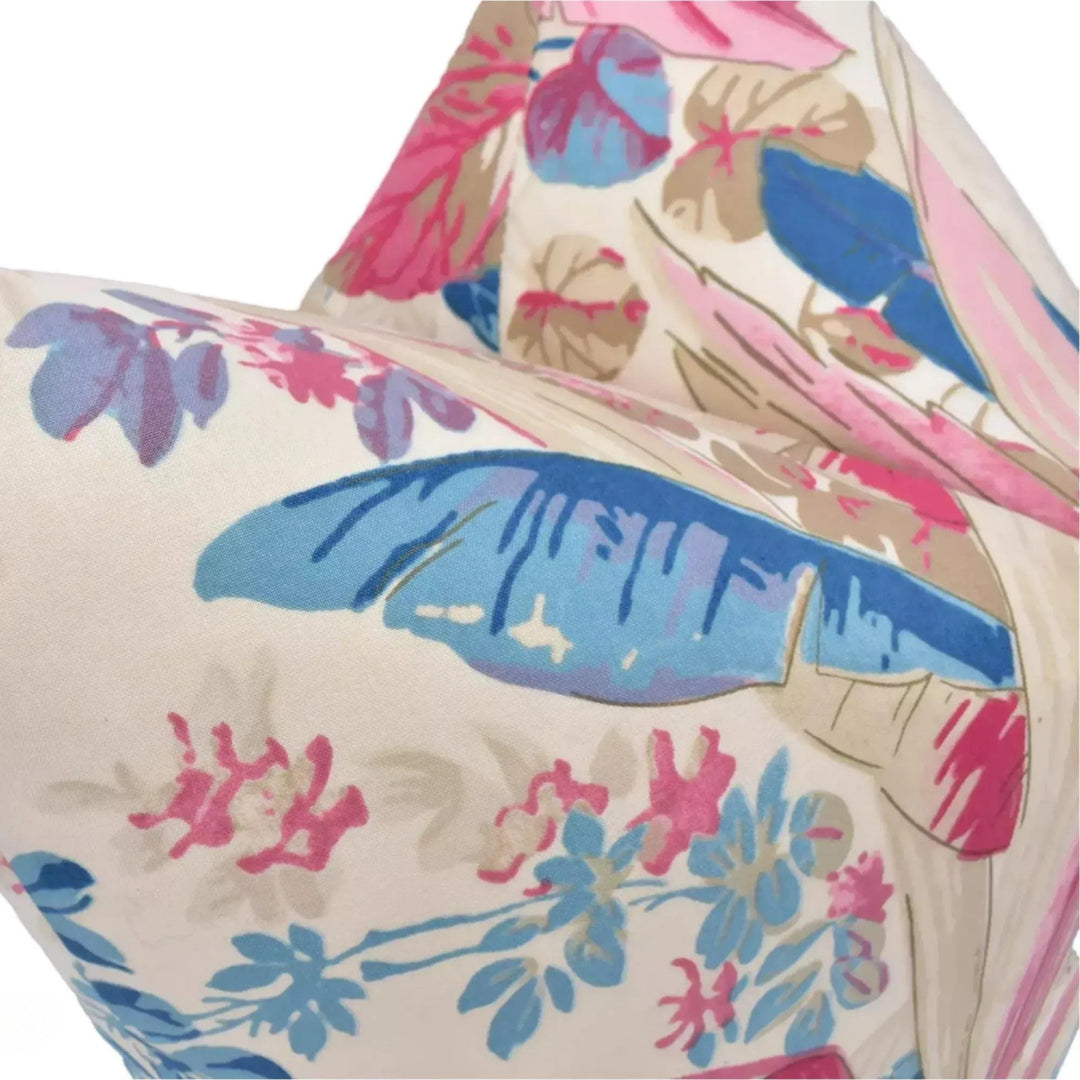 a close-up view of a colorful, floral-patterned fabric, possibly a pillow or cushion, with various shades of pink, blue, and green.
