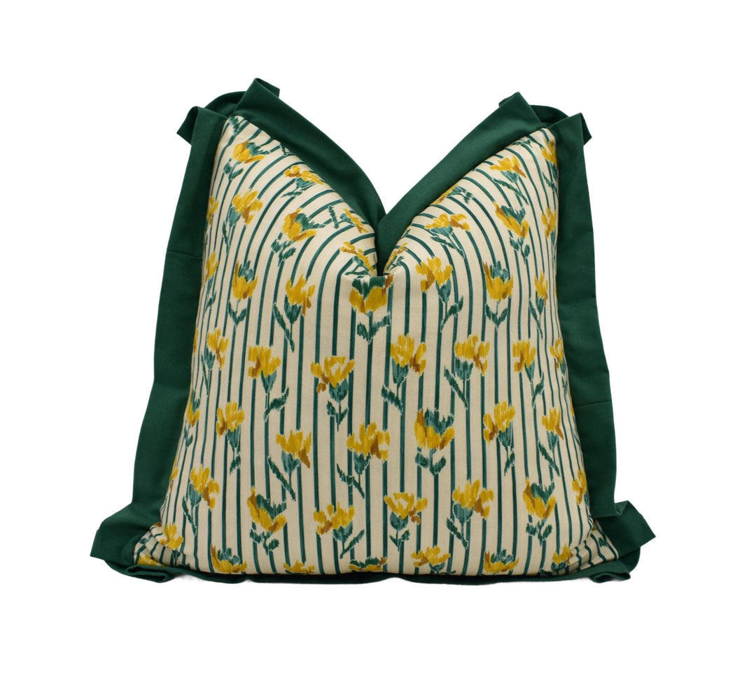 A decorative pillow with a floral pattern in shades of green and yellow.