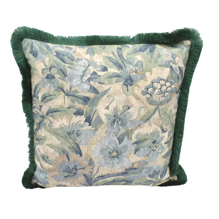 A decorative throw pillow with a floral print and green fringe is displayed against a white background.