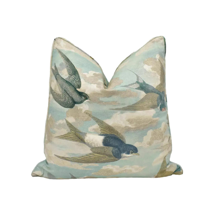 a decorative pillow with a cloud and bird pattern.