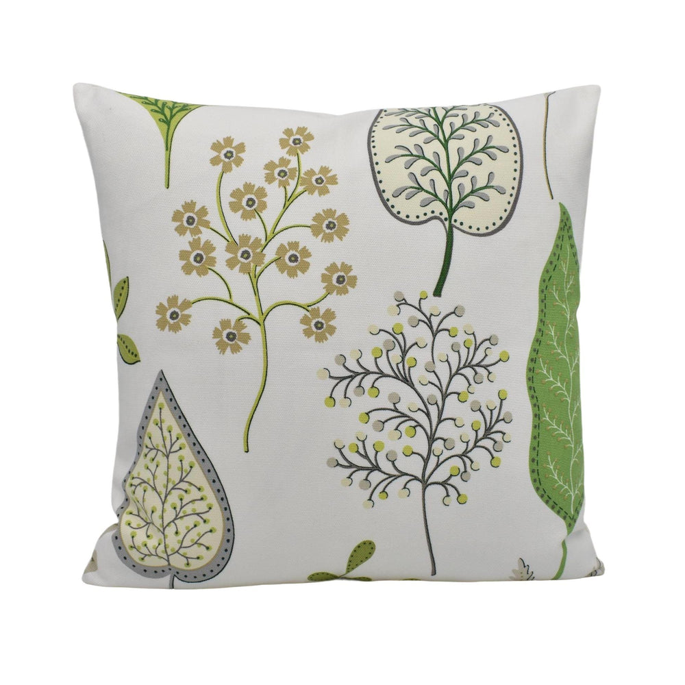 a white pillow with green leaves and flowers on it