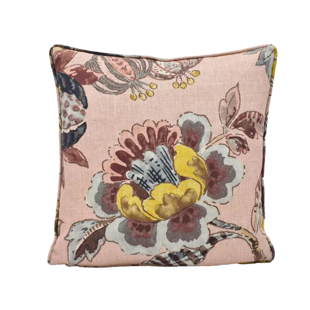 A square throw pillow with a floral print in shades of pink, yellow, and brown.