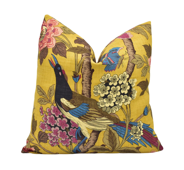 a yellow pillow with a bird and flowers on it