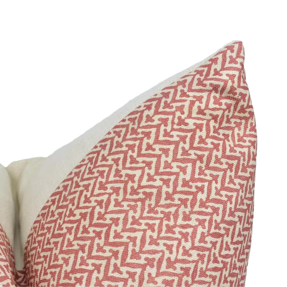 A close-up view of a red and white patterned pillow, with a zigzag design.