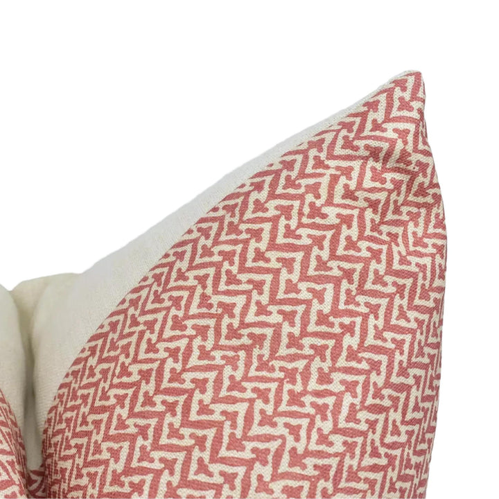 A close-up view of a red and white patterned pillow, with a zigzag design.
