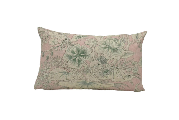 A decorative pillow with a floral pattern in shades of pink and green.