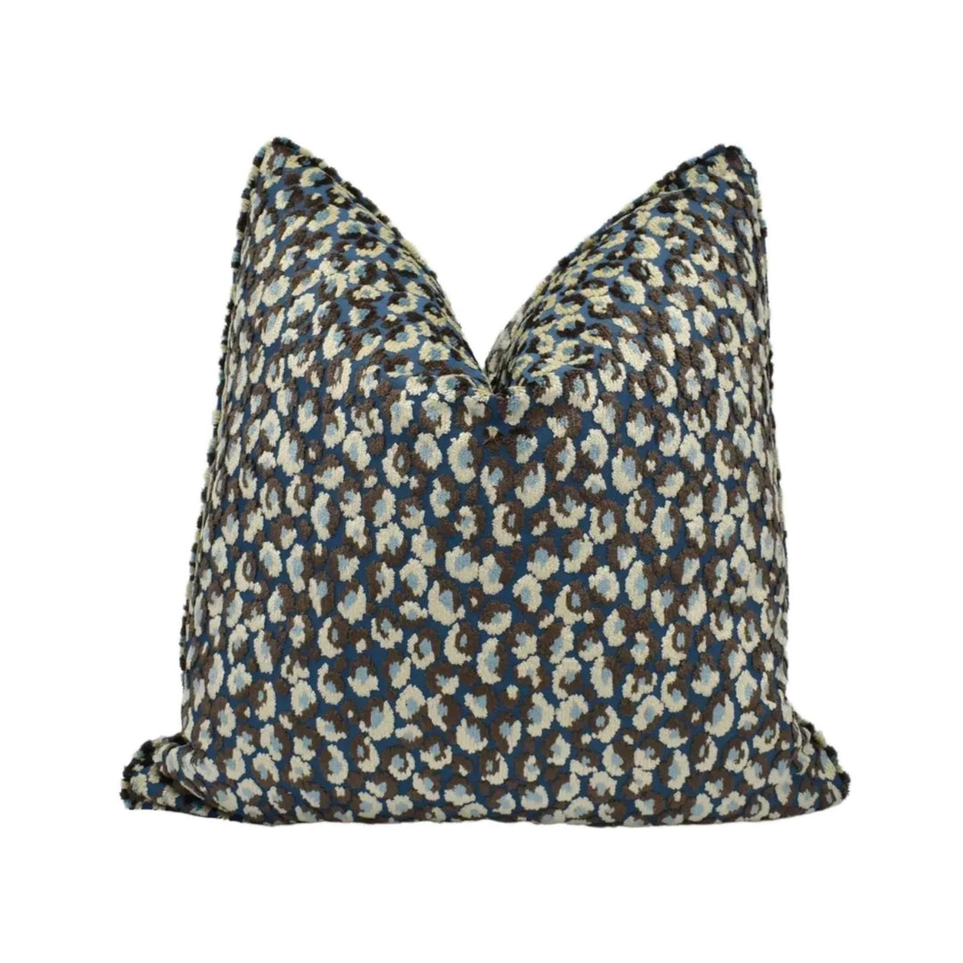 A decorative throw pillow with a pattern of blue and white animal spots - leopard print