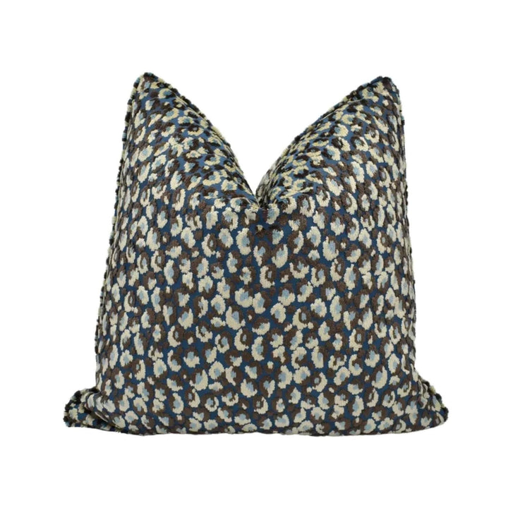 A decorative throw pillow with a pattern of blue and white animal spots - leopard print