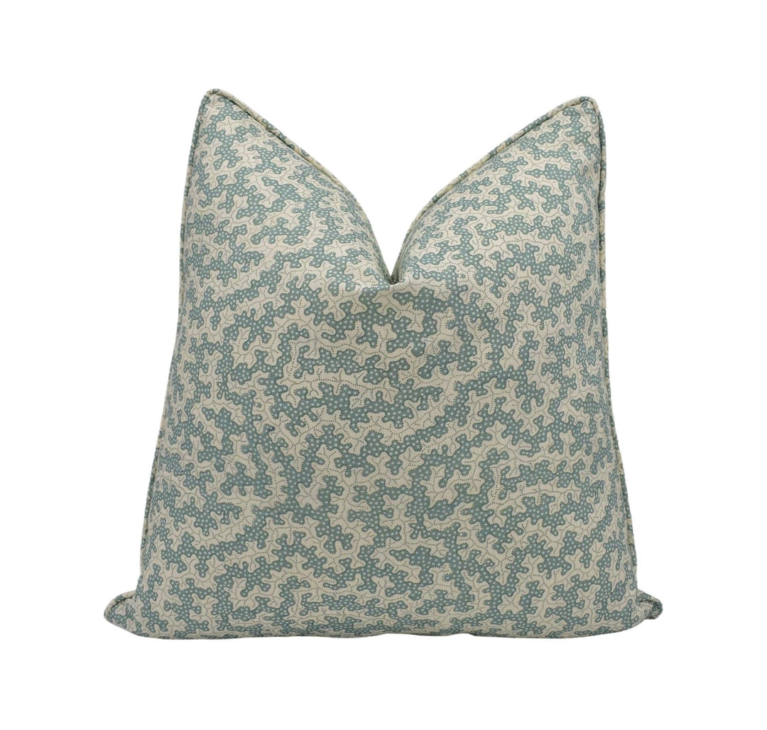 A single pillow with a geometric pattern in shades of green and beige.