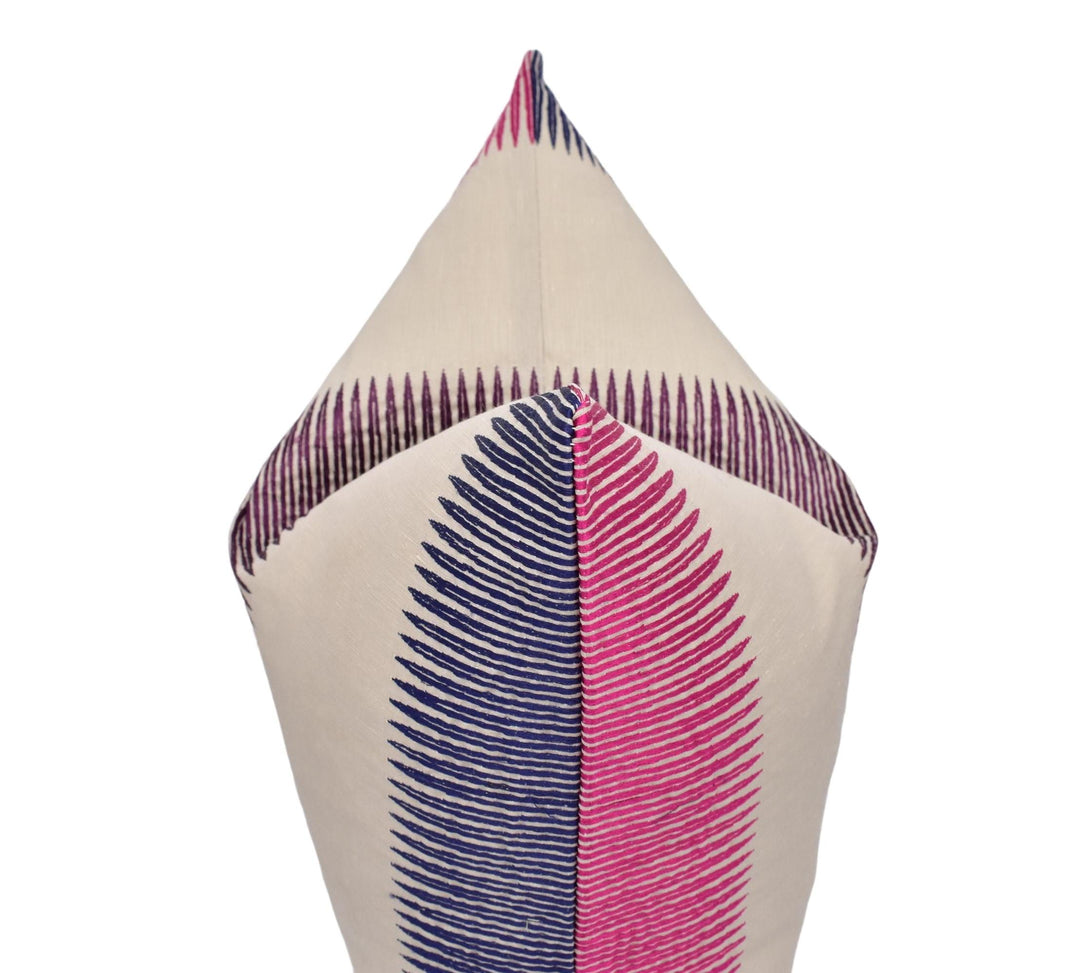 A close-up view of a decorative pillow with a striped pattern in shades of pink and blue.