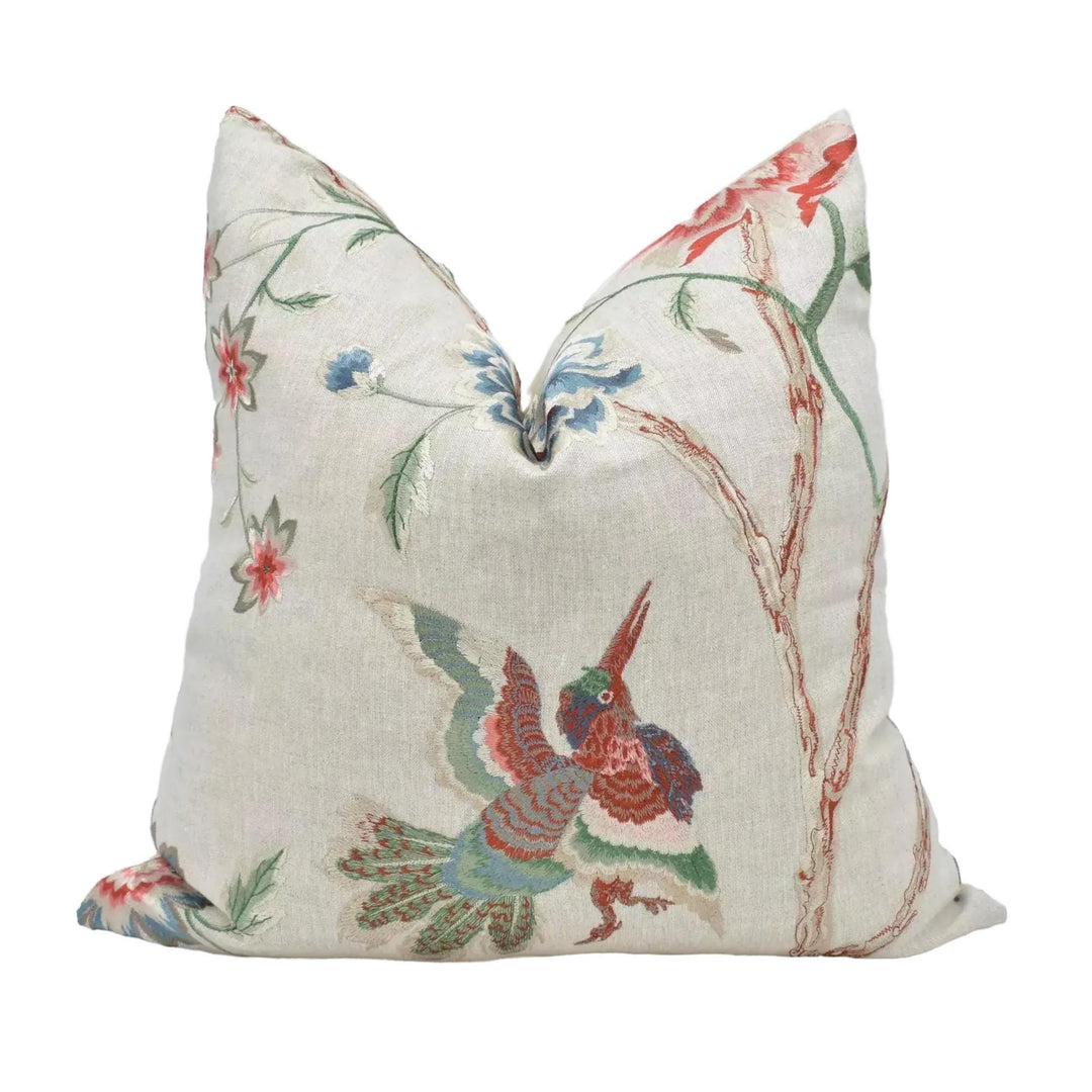 A decorative throw pillow with a floral and bird motif, featuring a variety of colors and patterns.