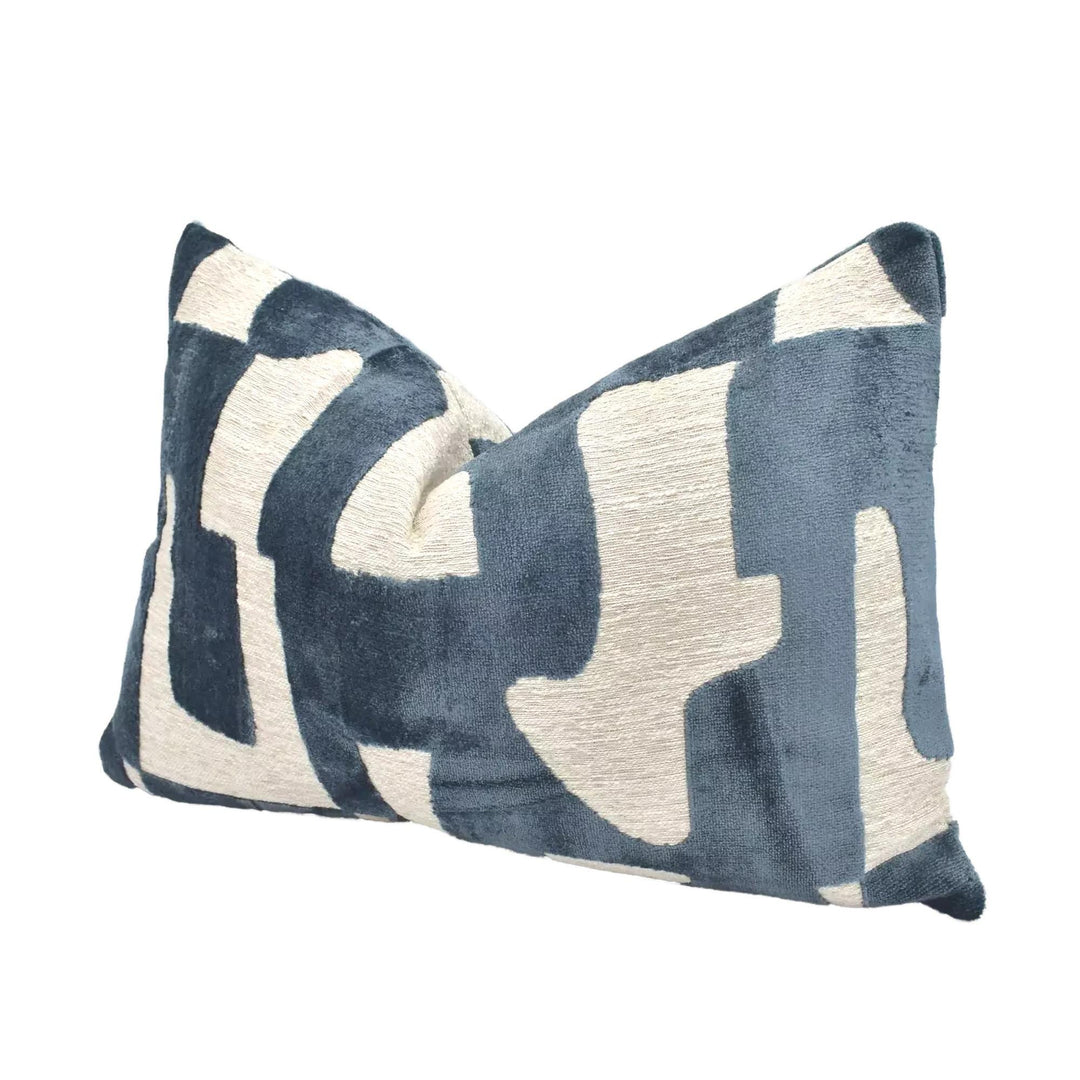 A blue and white patterned throw pillow is displayed against a white background.