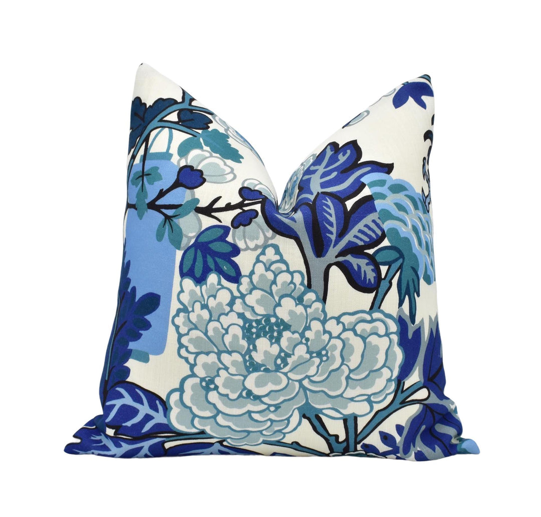 A decorative throw pillow with a floral pattern in shades of blue and white.