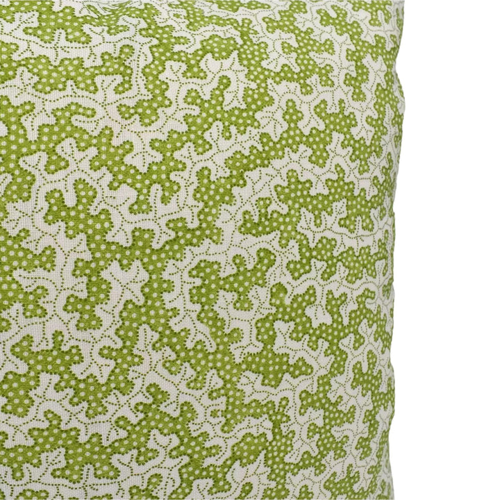 a close-up view of a green and white patterned fabric, possibly a pillow or cushion. The pattern consists of small white dots arranged in a repeating pattern across the fabric.