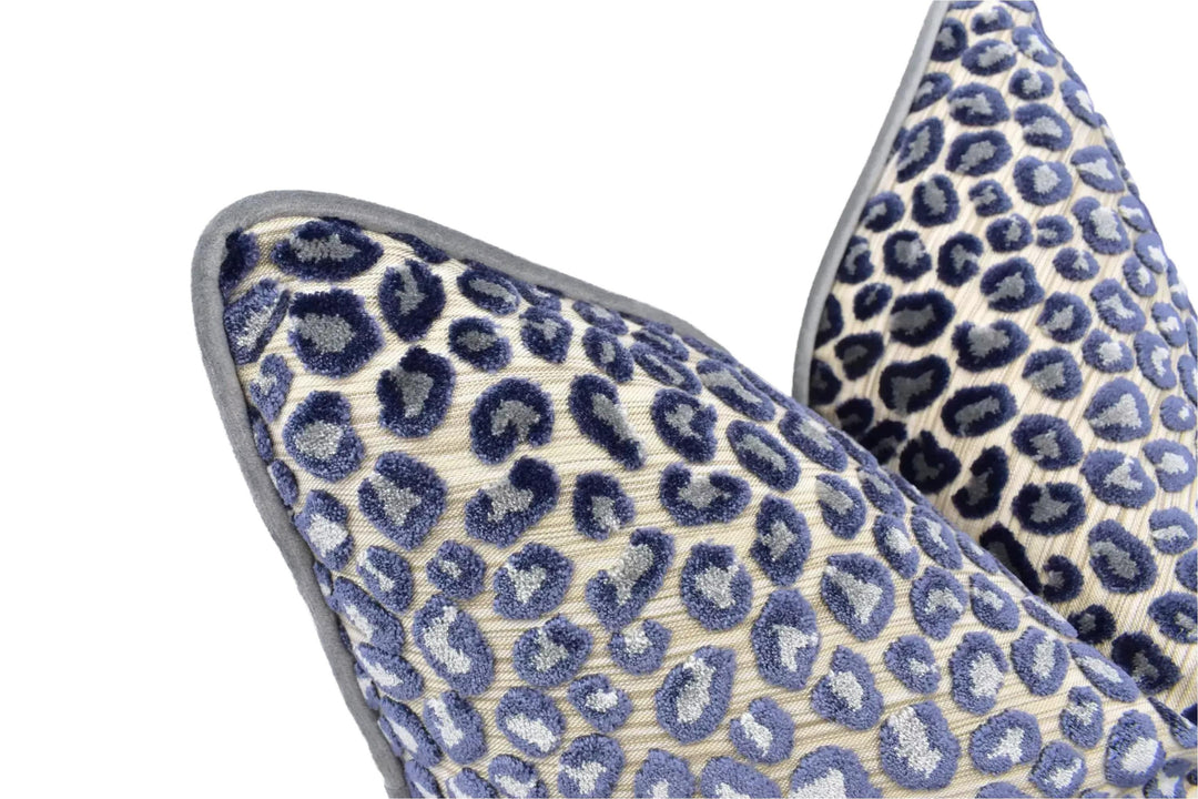 a close-up view of two decorative pillows with a leopard print pattern. The pillows have a textured surface with a repeating pattern of blue and white spots, creating a visually striking and eye-catching design.