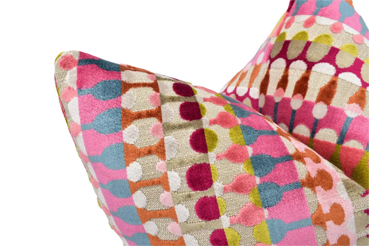 a close-up view of a colorful, patterned pillow with a vibrant mix of pink, orange, and yellow colors.