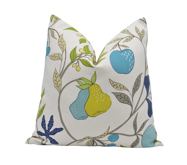 a white pillow with a colorful floral pattern of various fruits and leaves, including pears, apples, and blueberries.