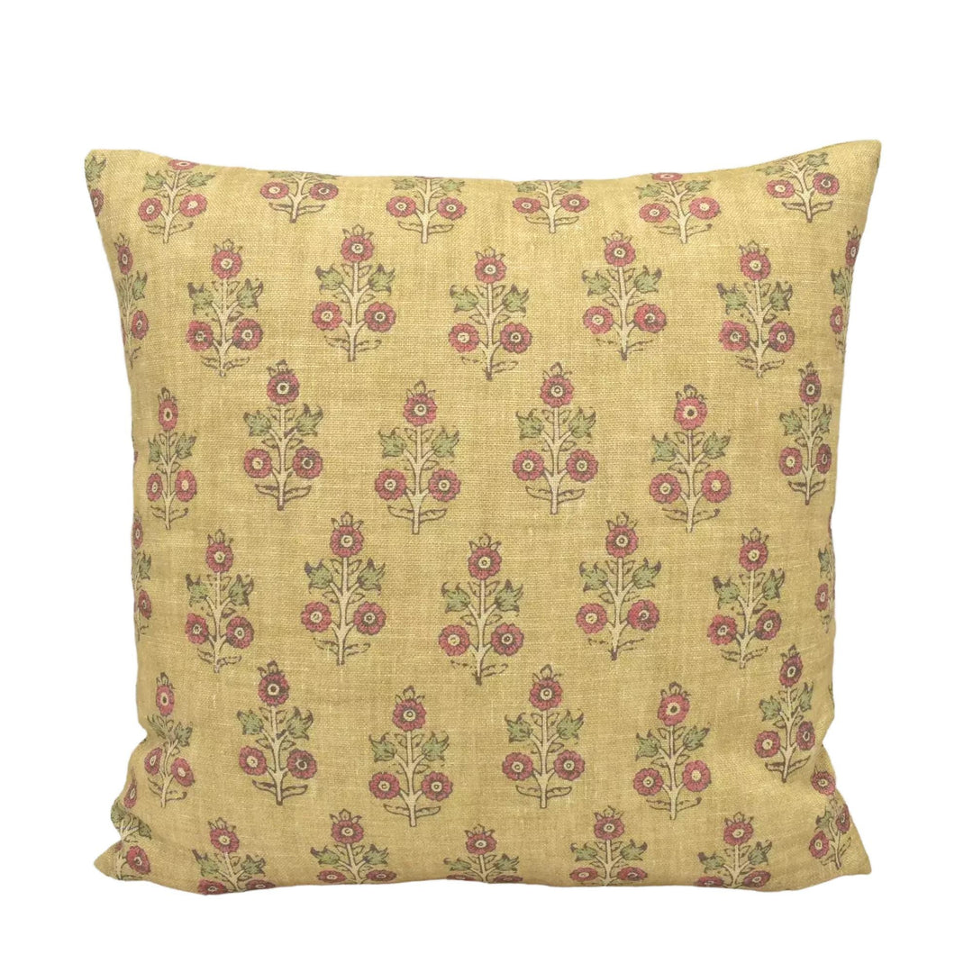A square yellow pillow with a repeating pattern of red flowers on a white background.