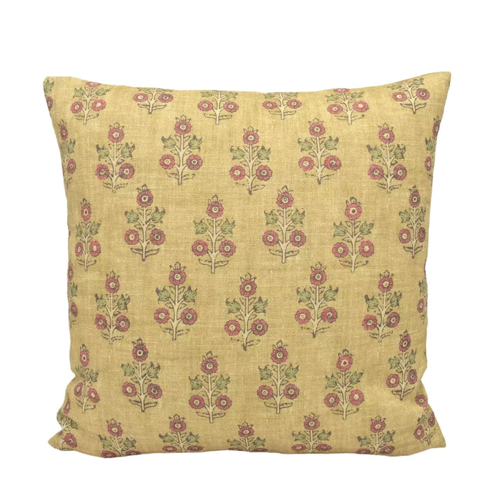 A square yellow pillow with a repeating pattern of red flowers on a white background.