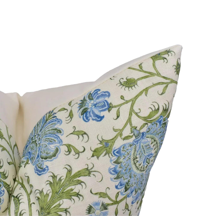 a close-up view of a decorative pillow with a floral pattern in shades of blue and green.