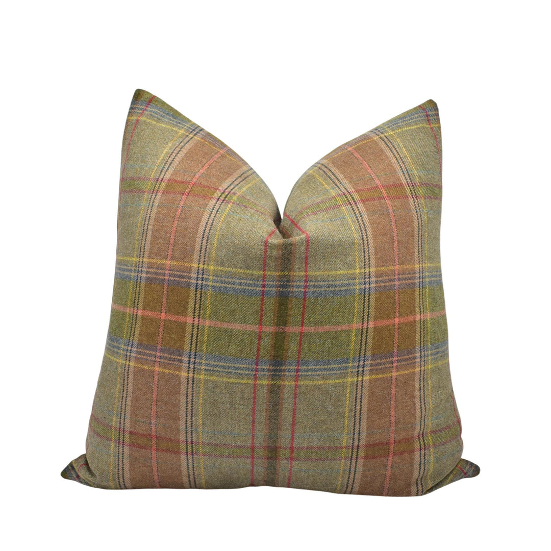 A pillow with a plaid pattern in shades of brown, green, and red.