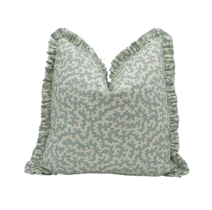A decorative throw pillow with a floral pattern and ruffled edges.