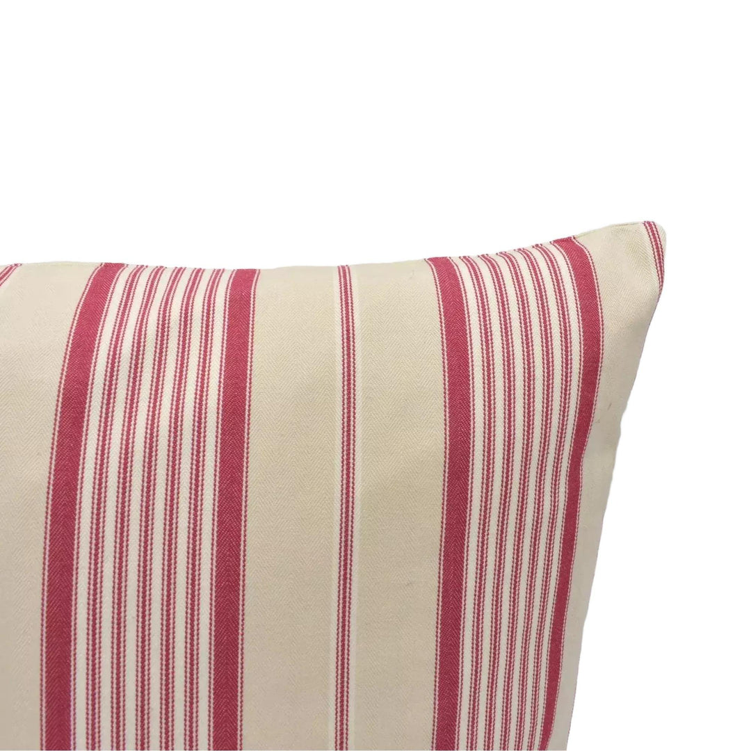 A close-up view of a striped pillow with alternating red and beige stripes.