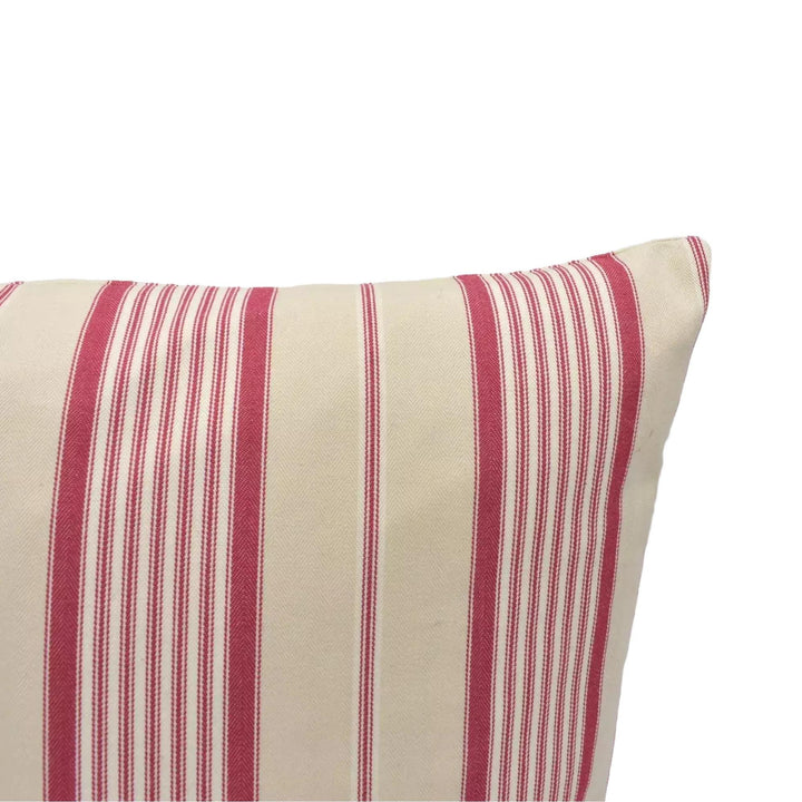 A close-up view of a striped pillow with alternating red and beige stripes.