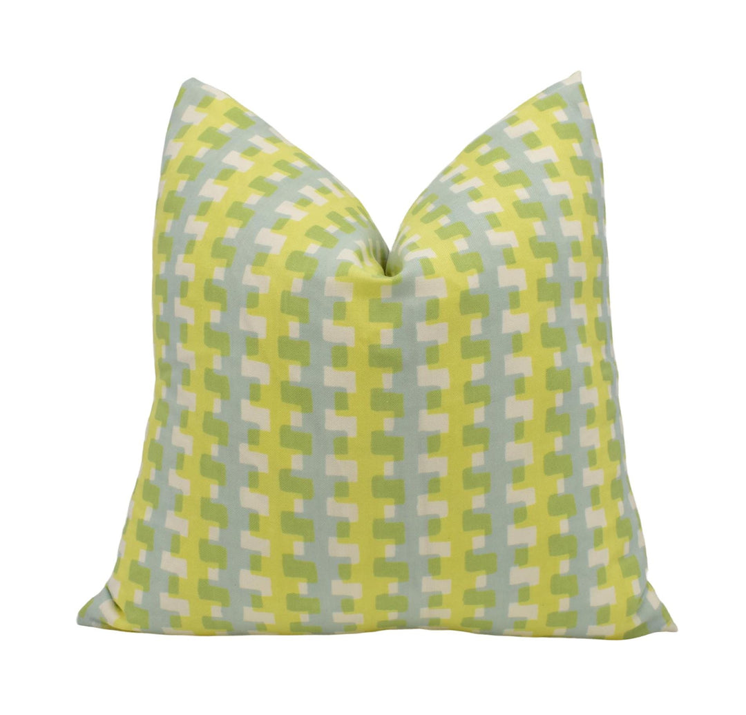 A yellow and green patterned throw pillow is shown against a white background.